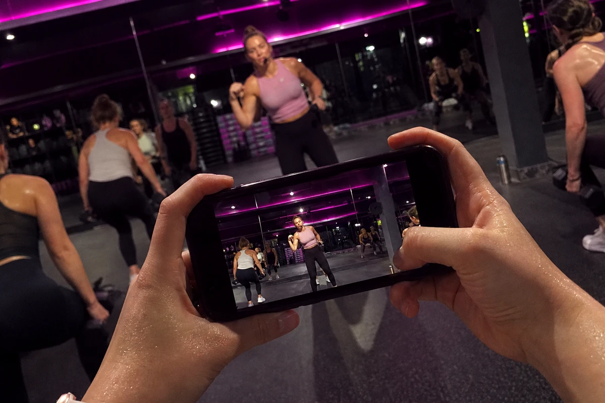 A person at the gym filming a water bottle after a workout