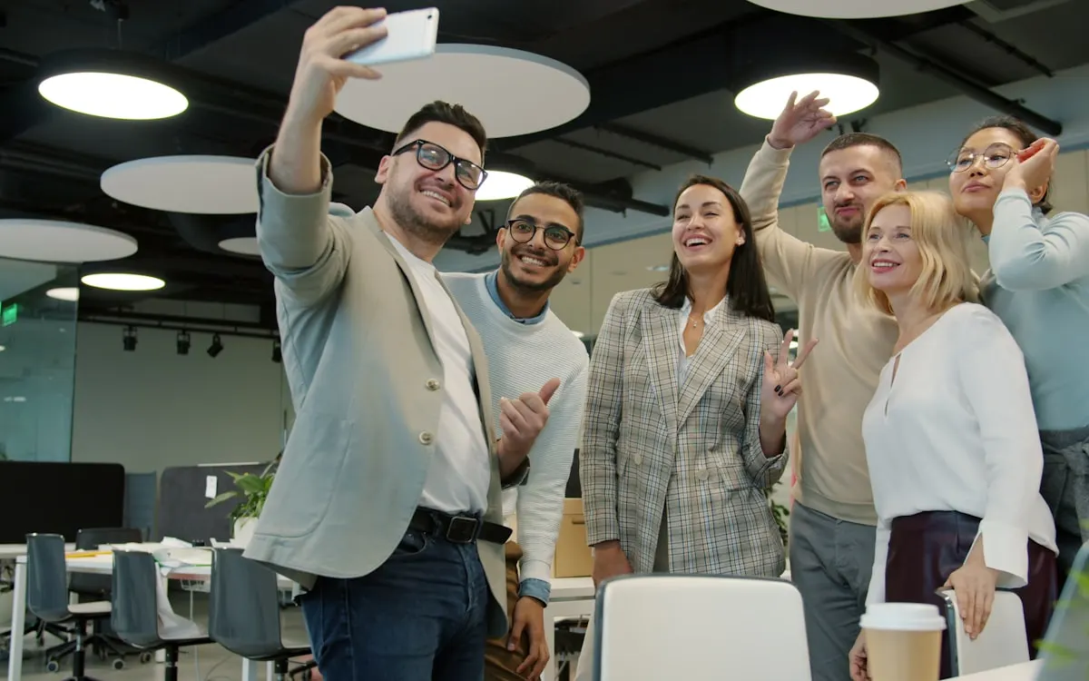Team of employees filming a video together at the office